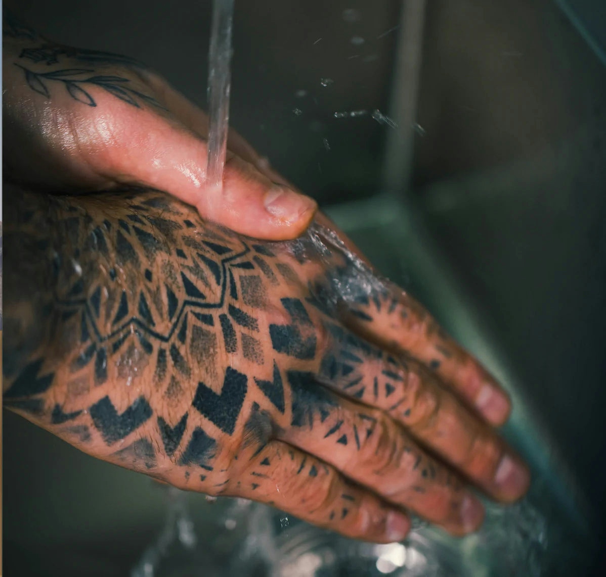 tattooed hands washing